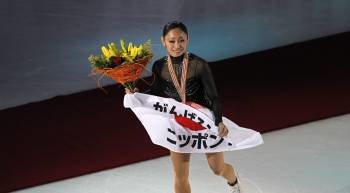 La japonesa Miki Ando muestra una bandera de su país con la medalla de oro conseguida en el programa libre femenino de los mundiales de patinaje artístico que se disputan en Moscú (Foto: YURI KOCHETKOV)