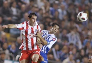 Diego Godín disputa un balón con el deportivista Valerón.
