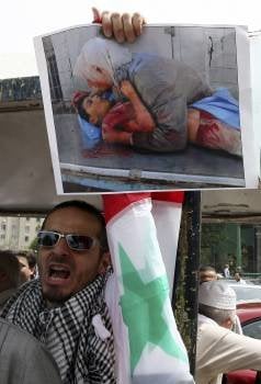 Un sirio muestra en El Cairo la foto de una víctima de Asad. (Foto: KHALED ELFIQUI)