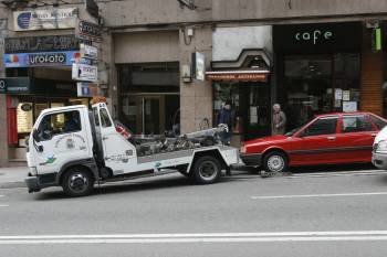 La grúa retira un coche que estaba mal estacionado en la calle Juan XXIII. (Foto: MIGUEL ÁNGEL)