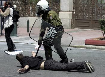Un agente de la Policía griega antidisturbios se enfrenta a un manifestante durante una protesta con motivo de la huelga general que vive hoy Grecia.