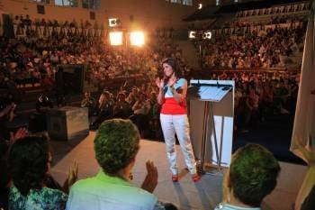 Isabel Pérez, en el escenario, aplaude a sus compañeros de lista, sentados. Detrás, los militantes y simpatizantes. (Foto: JOSÉ PAZ)
