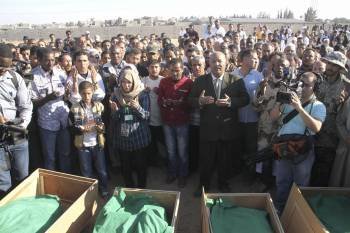 Varios libios rezan junto a los ataúdes de las víctimas de un ataque de la OTAN en Trípoli. (Foto: MARK JONES)