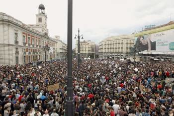 Miles de personas se concentraron en la tarde-noche de ayer en la Puerta del Sol madrileña, vigiladas de cerca por la Policía. (Foto: J.J. GUILLÉN)