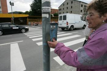 Una mujer pulsa el botón del semáforo que regula el paso en el lugar en que se produjo el siniestro. (Foto: Marcos Atrio)