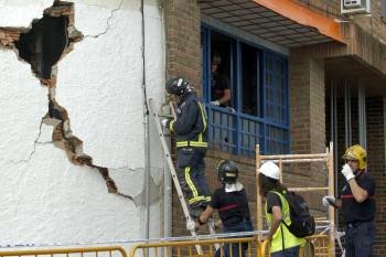 Los bomberos contemplan una de las grietas abiertas en un edificio de Lorca. (Foto: ISRAEL SÁNCHEZ)