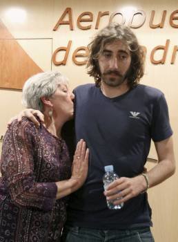 El fotógrafo español Manu Brabo, junto a su madre, al inicio de la rueda de prensa que ofreció hoy a su llegada al aeropuerto de Madrid Barajas procedente de Túnez.