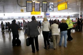 Pasasjeros observan las pantallas informativas en el aeropuerto de Glasgow, Reino Unido.