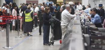 Pasajeros se interesan por sus vuelos en el aeropuerto de Glasgow. (Foto: DANNY LAWSON)