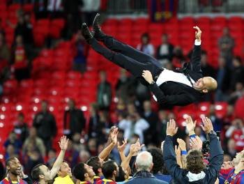Los jugadores del Barcelona hacen volar por los aires a Pep Guardiola al final del partido en Londres. (Foto: F. TRUEBA)