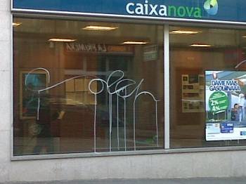 Una de las pintadas, en el ventanal de una entidad bancaria. (Foto: )