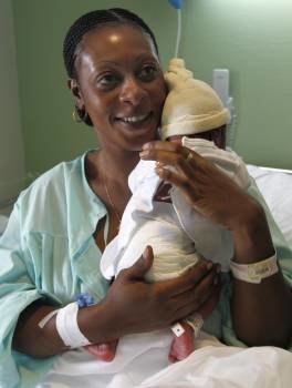 Antonino, el bebé que nació en pleno vuelo Malabo-Madrid, es sujetado por su madre, una mujer guineana de 38 años que reside en Móstoles, en el hospital de La Paz.