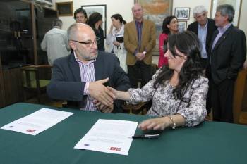 Francisco Rodríguez e Isabel Pérez se dan la mano tras firmar el documento acordado por las comisiones negociadoras (al fondo). (Foto: JOSÉ PAZ)