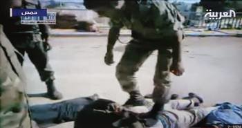 Imagen de la televisión Al Arabiya que muestra a un soldado pisando a un hombre esposado. (Foto: )