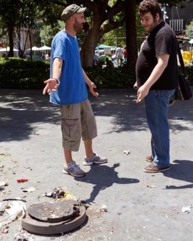 Dos jóvenes junto a los restos de la papelera de la Plaza de España de Palma, donde ha explosionado un potente petardo que ha causado dos heridos. Foto: EFE