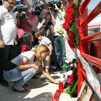 Una mujer coloca una vela esta mañana, durante el homenaje en el que han participado decenas de familiares y amigos de las doce personas que fallecieron arrolladas por un tren en Castelldefels hace hoy un año. Foto: EFE