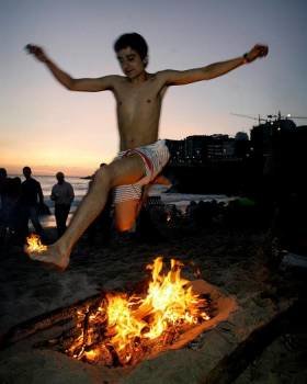 Un joven salta una hoguera en la Playa del Orzán, en A Coruña, durante tradicional noche de 'San Juan'. Foto: EFE