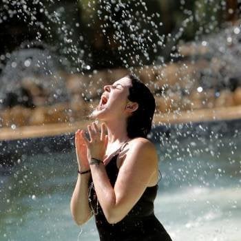 Una jóven se refresca en una fuente del Parque de María Luisa en Sevilla debido a las altas temperaturas. Foto: EFE