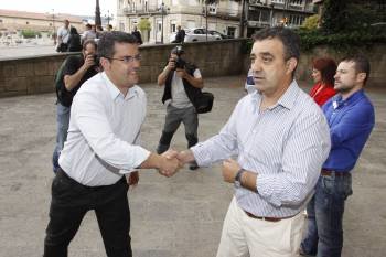Andrade (izquierda) saluda a Castro, en la entrada del Pazo de Xustiza, antes del sorteo que atribuyó la Alcaldía de Os Blancos al PP. (Foto: XESÚS FARIÑAS)