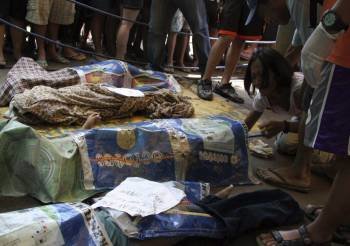 Una mujer filipina llora la pérdida de varios miembros de su familia tras las repentinas inundaciones que afectaron a una zona residencial de la ciudad de Davao, en el sur de Filipinas, hoy, miércoles 29 de junio de 2011. Catorce personas han muerto debid
