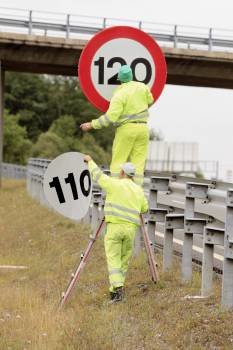 Operarios de la Diputación Foral de Álava retiran las pegatinas que indica el límite de velocidad de 110 km. (Foto: DAVID AGUILAR)
