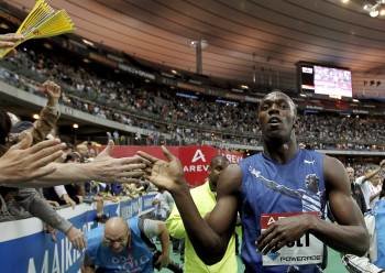Bolt recibe la felicitación de los aficionados franceses tras la prueba en París.? (Foto: KERIM OKTEN)