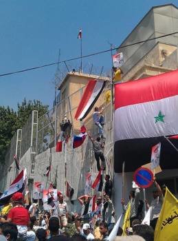 Seguidores de Al Assad colocando una bandera siria en la entrada de la embajada estadounidense. (Foto: Youssef Badawi)