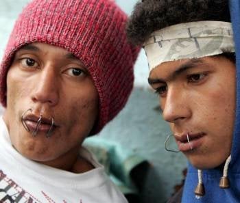 Dos presos muestran sus bocas atravesadas con alambres. Foto: Andrés Cristaldo