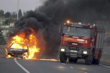 En la A-66 el incendio de un coche provocó retenciones para poder entrar en Salamanca. (Foto: J. M. GARCÍA)
