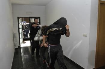Los detenidos. Uno de ellos saca el puño para agredir a los reporteros gráficos. (Foto: MIGUEL ÁNGEL)
