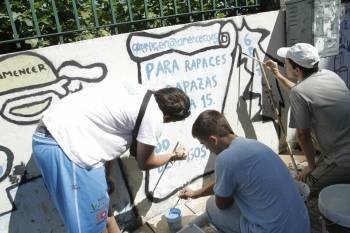 Miembros de la asociación repintando el muro de la calle Saénz Díez. (Foto: MIGUEL ÁNGEL)
