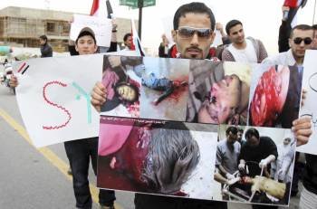 Opositores sirios muestran fotos de víctimas de la represión del Gobierno de Al Asad. (Foto: ARCHIVO)