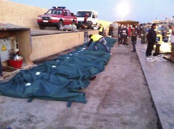Una fila de cadáveres del barco procedente de Libia yacen en un muelle del puerto de Lampedusa? (Foto: DESIDERIO )