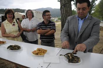 Xurxo Rodríguez (derecha), junto a vecinos, participa en la degustación de las anguilas. (Foto: MIARTIÑO PINAL)
