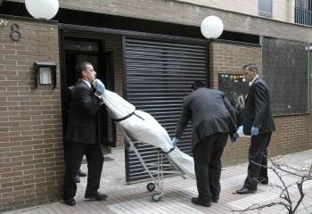 Operarios de los servicios funerarios retiran el cadáver de la mujer asesinada en Madrid. (Foto: KIKE HUESCA)