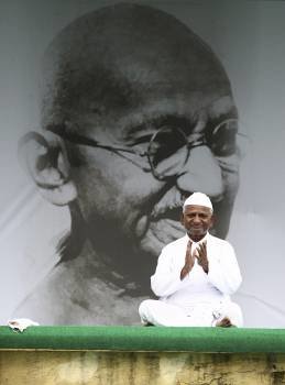 El activista indio Anna Hazare se sienta junto a una gigantesca fotografía de Mahatma Gandhi en Nueva Delhi (India) 