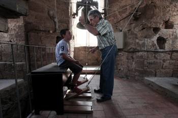 Arnau, de 7 años, es instruido por el campanero de la iglesia de Les Borges Blanques, Pere Giner (Foto: DAVID BESORA)