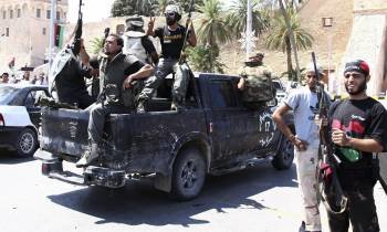 Combatientes rebeldes armados en una furgoneta 'pickup', hoy miércoles 24 de agosto de 2011 en Tripoli, Libia.Tras la toma del palacio presidencial en Trípoli, símbolo del régimen libio, los rebeldes buscan hoy la rendición de Muamar al Gadafi.