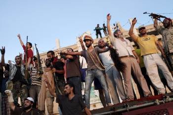 Un rebelde libio exhibe la gorra, el bastón de mando y un collar de Gadafi tras ocupar el palacio presidencial. (Foto: MARCO SALUSTRO)