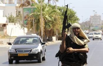 Un soldado rebelde vigila un puesto de control en Trípoli. (Foto: MOHAMED MESSARA)