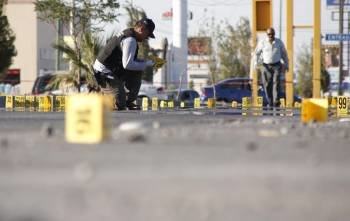 Un perito forense reúne evidencias en la zona donde tres agentes de la policía de Ciudad Juárez fueron asesinados , en una de las calles de dicha urbe mexicana.  (Foto: EFE)