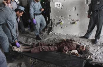 Militares afganos junto al cadáver de un terrorista talibán. (Foto: S. SABAWOON)