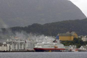 Una columna de humo se eleva sobre un crucero de la compañía Hurtigruten tras registrarse un incendio en el que dos personas resultaron heridas, en Aalesund, en el oeste de Noruega (Foto: EFE)