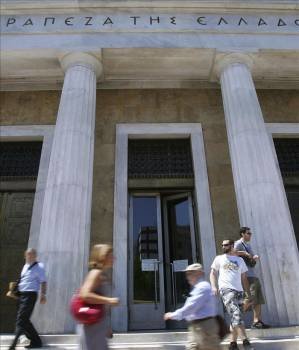 Viandantes enfrente del banco central de Grecia (Foto: EFE)