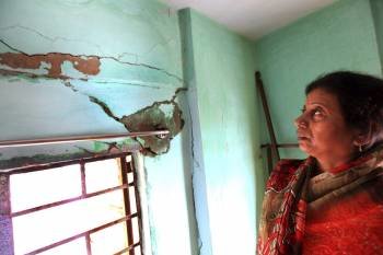 Sharmila Roy muestra las grietas aparecidas en las paredes de su casa tras el terremoto de 6,8 grados en la escala Richter que sacudió anoche el noreste de la India y Nepal (Foto: EFE)
