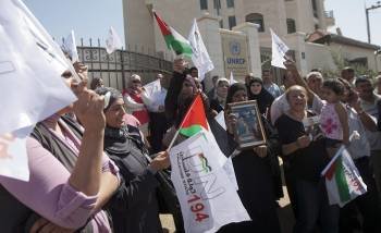Palestinas con pancartas con el lema 'Estado palestino 194' frente a la sede de la ONU en Ramala.  (Foto: ATEF SAFADI)