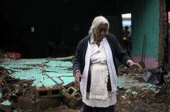 Una mujer de 81 años camina junto a su vivienda derrumbada hoy, lunes 19 de septiembre de 2011, en Cuilapa, Santa Rosa, a 60 kilometros de Ciudad Guatemala. (Foto: EFE)