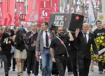 Varios profesores escenifican el entierro de la enseñanza pública durante la manifestación que se desarrolló hoy en Santiago de Compostela.