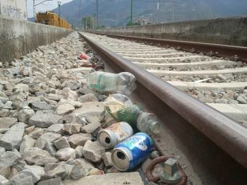 Restos de botellas y latas en las vías del tren lindantes con la explanada de la estación de autobuses. (Foto: LUIS BLANCO)