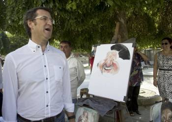 Feijóo se ríe ante una caricatura del alcalde de Lugo, López Orozco, en su paseo por la ciudad. (Foto: ELISEO TRIGO)